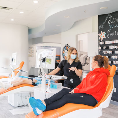 Patient consultation at OPD Smiles, orthodontist discussing treatment options with a new patient in a modern dental office setting.